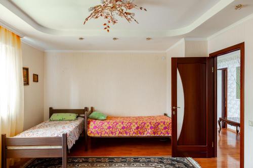 阿斯塔纳Hostel Astana的一间卧室配有两张床和吊灯。