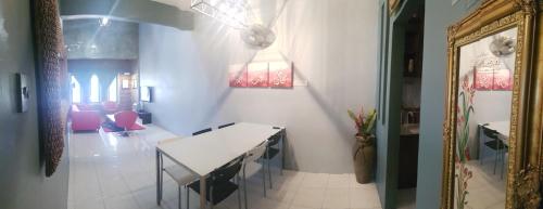 怡保Andak Home2stay的一间设有白色桌子和粉红色椅子的用餐室