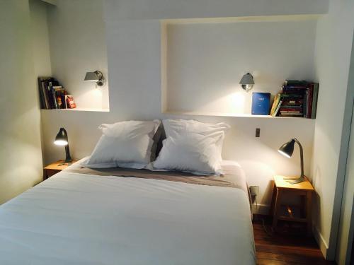 巴黎Chez Vous ST HONORÉ的一间卧室配有带白色床单和枕头的床。