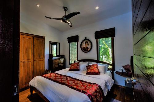 拉迈Stunning villa with ocean views and free car的一间卧室配有一张床和吊扇