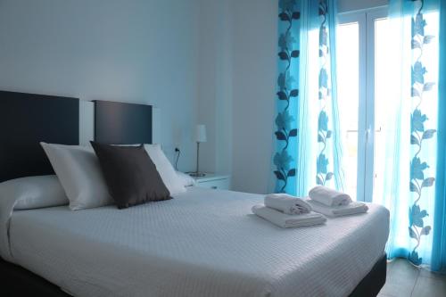 托莱多Apartamentos Homelife Roca Tarpeya的一间卧室配有一张床,上面有两条毛巾