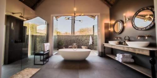 MatlhagameNkala Safari Lodge的大型浴室设有两个盥洗盆和一个大浴缸。