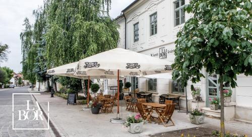 托考伊LaBor Kvártély的一个带桌椅的户外咖啡厅,位于伞下