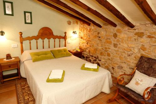AlbocácerCasa Rural Mas de Sant Pau - Turistrat.的一间卧室设有一张床和石墙