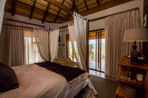MkuzeMpeti Lodge的一间卧室设有一张床和一个大窗户