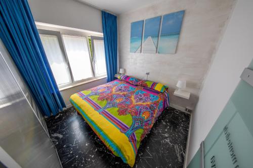 加尔达湖滨思丽维公寓的小卧室配有一张带色彩缤纷的被子的床