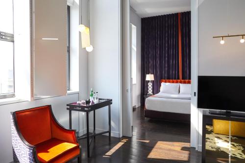 蒙特利尔圣保罗酒店的配有床、椅子和电视的房间