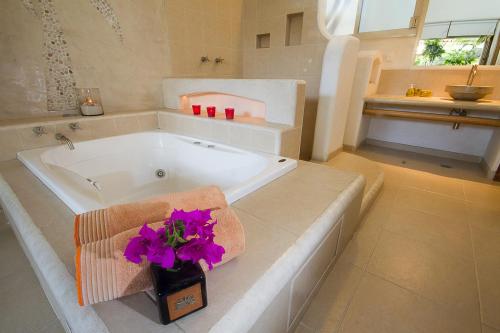 锡瓦塔塔内霍Villas Naomi的浴室配有带紫色鲜花的浴缸。