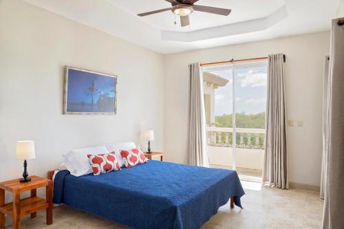IguanaRio Dulce Ocean View Penthouse V-16的一间卧室设有蓝色的床和大窗户