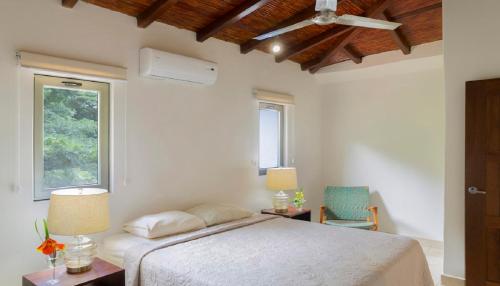 IguanaTown House 6的白色的卧室设有床和窗户