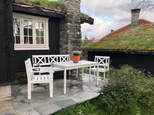 勒罗斯Svenskveien 23b的庭院里配有一张白色的桌子和两把椅子