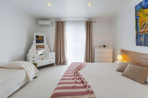 富尔纳斯Casa do Poema的白色的卧室设有床和窗户