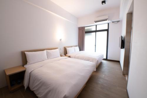 台中市LIANN Hotel 黎安商旅的酒店客房设有两张床和窗户。