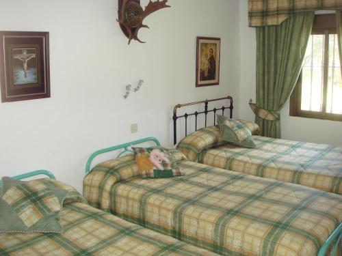 安度亚尔圣何塞酒店的一间卧室配有两张床,床上有一个娃娃