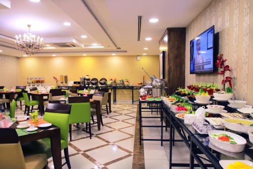 安曼城市玫瑰套房酒店的餐厅设有长桌和绿色椅子