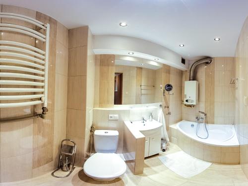 霍茹夫Batory Apartament的浴室配有卫生间、盥洗盆和浴缸。