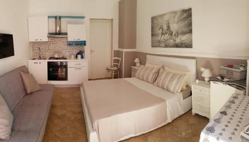 莱切Il Casale dei Principi的一间带白色大床的卧室和一间厨房