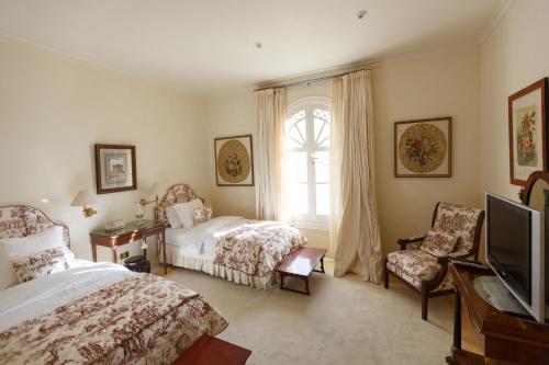 马斯帕洛马斯Magnificent Villa Piera的一间卧室设有两张床、一台电视和一扇窗户。