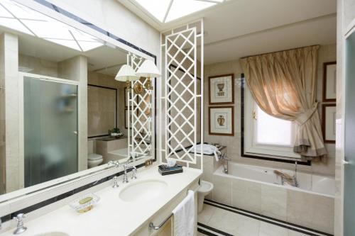 马斯帕洛马斯Magnificent Villa Piera的一间带水槽、浴缸和镜子的浴室