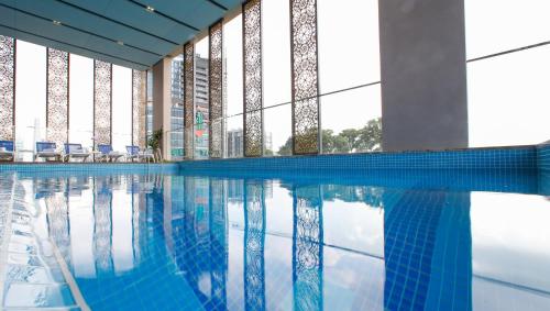 胡志明市兰花西贡酒店的蓝色建筑中的游泳池