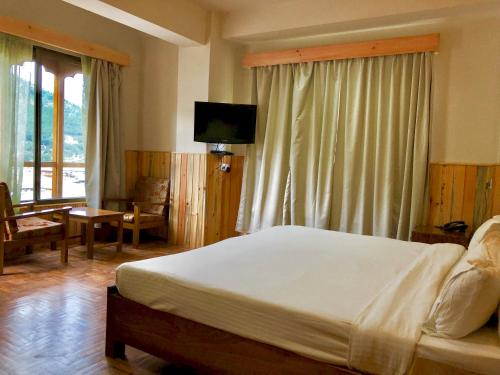 廷布卡木肃穆旅馆的一间卧室配有一张大床和一台电视。