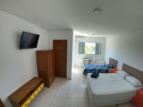 伯迪亚哥Pousada Costa da Riviera的一间配备有沙发、床和电视的客房