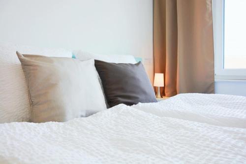 埃姆斯代滕X-Hotel的一张带两个枕头和白色床单的床