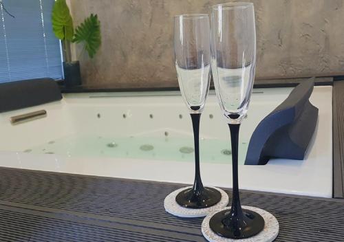 奇尼斯风中玫瑰别墅公寓的浴缸旁的桌子上放两杯香槟酒