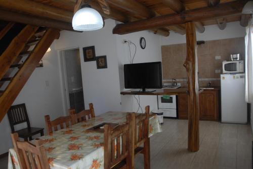埃斯克尔Cabañas Abelard的厨房以及带桌子和电视的用餐室。