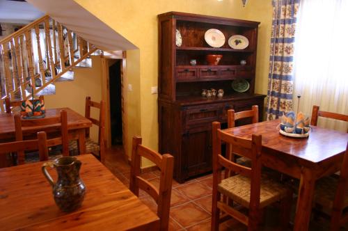 布尔戈斯Casa Rural Valle Esgueva的一间带桌椅和楼梯的用餐室