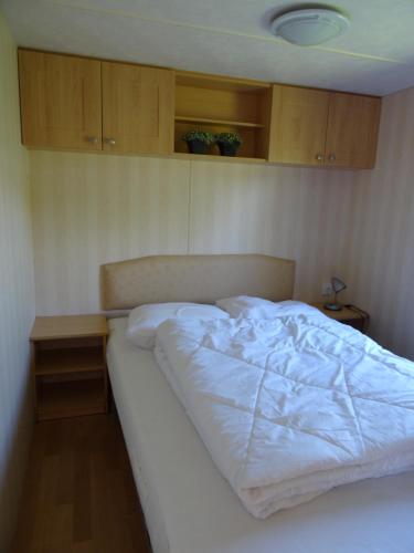 塞罗斯凯尔克Chalet de Boshoorn的卧室内的一张床位,配有木制橱柜