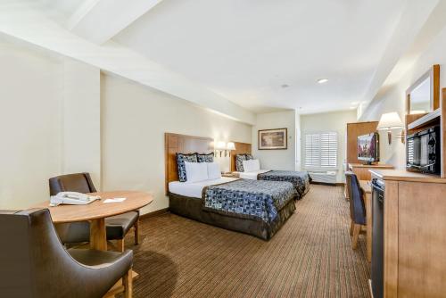 安纳海姆阿纳海姆沙漠旅馆及套房的酒店客房配有一张床铺和一张桌子。