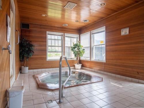 坎卢普斯坎卢普斯朗奇兰汽车旅馆的木墙客房的浴室设有热水浴缸