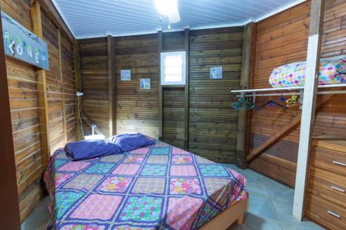 DesbassynsChez Seb & Klo的卧室配有一张床铺,位于带木墙的房间内