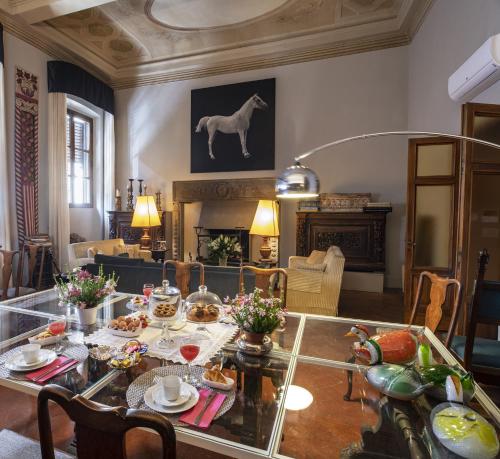 佛罗伦萨波迪赛丽酒店的客厅配有桌子,墙上挂有马画