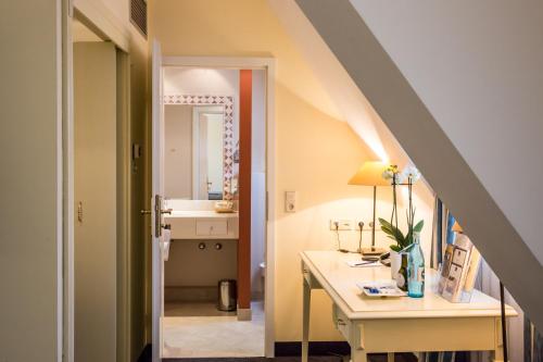 维尔茨堡雷布斯托克贝斯特韦斯特高级酒店的一间带水槽的浴室和一张带镜子的书桌