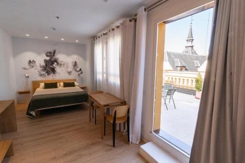 马德里Plaza Mayor Suites & Apartments的一间卧室设有一张床和一个大窗户
