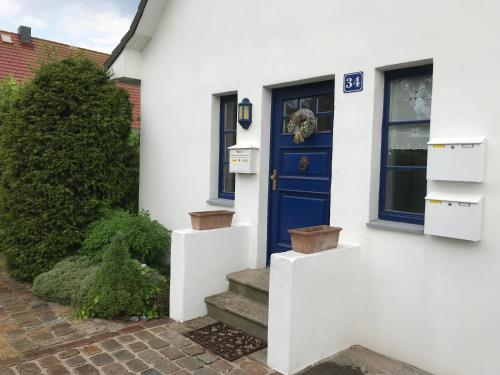格洛韦Ferienwohnung Fritzi的白色房子的蓝色门,有楼梯