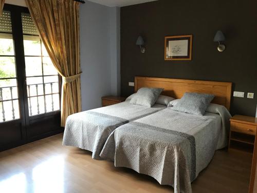 Poza de la Sal卡萨马丁酒店的一间卧室设有两张床和窗户。