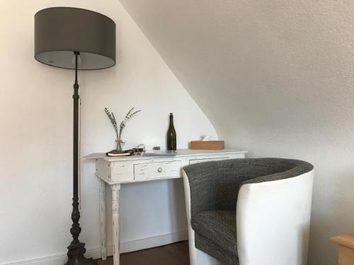 莱茵河畔威尔Ferienwohnung Haltingen的一张带灯和椅子的白色书桌