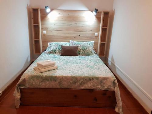 圣克鲁什达什弗洛里什Casa da Cruz的一间卧室配有一张带木制床头板的床