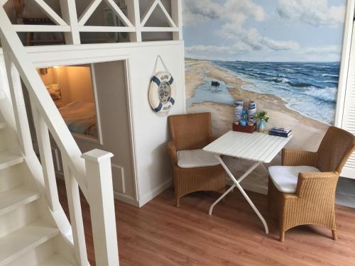 Rijnsburg德拜茨媞住宿加早餐旅馆的一张桌子和椅子,在一幅海洋画的房间里