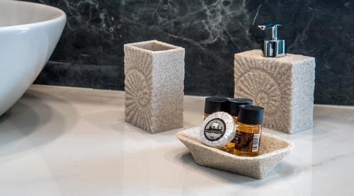 雅典迪西奥酒店的一间带3个肥皂分配器和水槽的浴室