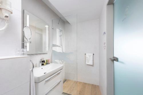 尼赖吉哈佐Pangea Hotel的白色的浴室设有水槽和镜子