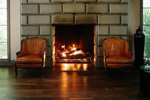 扬特维尔尤特维尔酒店的带壁炉的客厅配有两把椅子