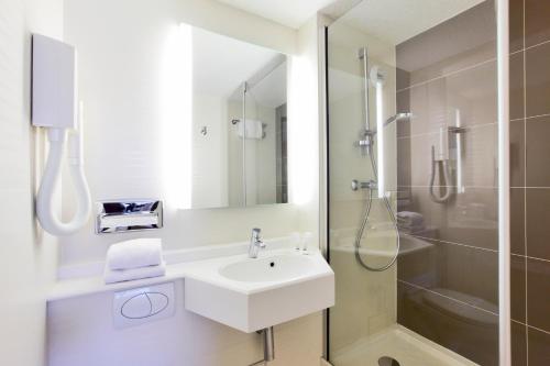 讷韦尔基里亚德内维尔中央酒店的白色的浴室设有水槽和淋浴。