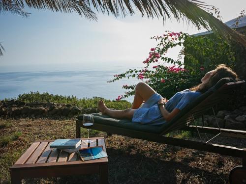 ScauriDammuso sulla scogliera - Pantelleria的躺在椅子上看海洋的女人