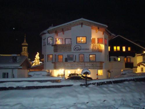 盖洛斯alpenrose hotel-garni的一座白色的大建筑,前面有圣诞树