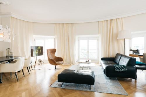 美因茨奥斯特纳霍夫套房公寓的客厅配有黑色沙发和桌子