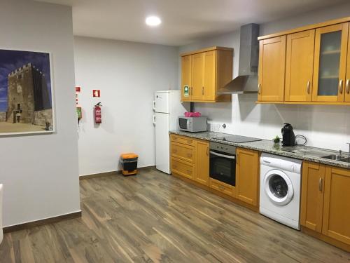 拉梅戈Apartamento da Seara "Douro"的厨房配有木制橱柜和洗衣机。